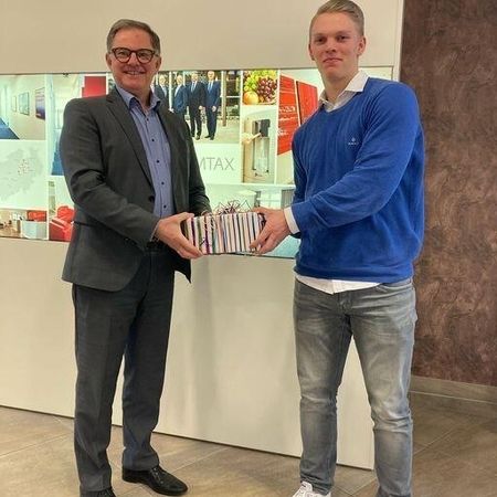 Junger Mann erhält Geschenk von älterem Mann im Anzug