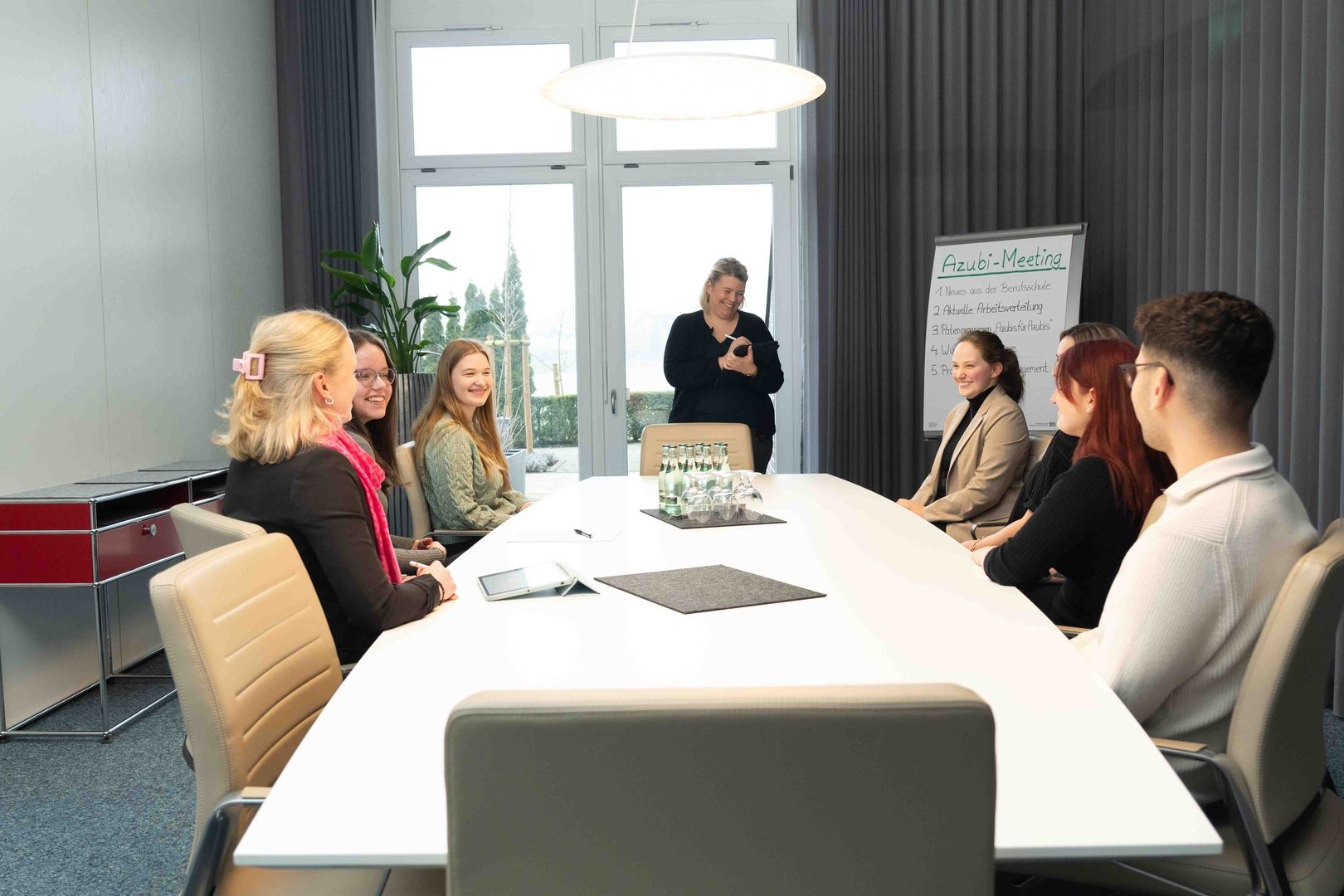 Teilnehmer sitzen an einem Konferenztisch und führen ein Azubi Meeting